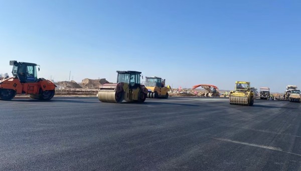 近日，在ok138cn太阳集团古天乐兰州新区城市矿产与表面处理产业园区（二期）周边基础设施项目—园区西路南延段（纬五十路至纬二十八路）项目现场，随着一辆辆运料车平稳驶入，摊铺机将滚烫的沥青混合料均匀铺开，标志着项